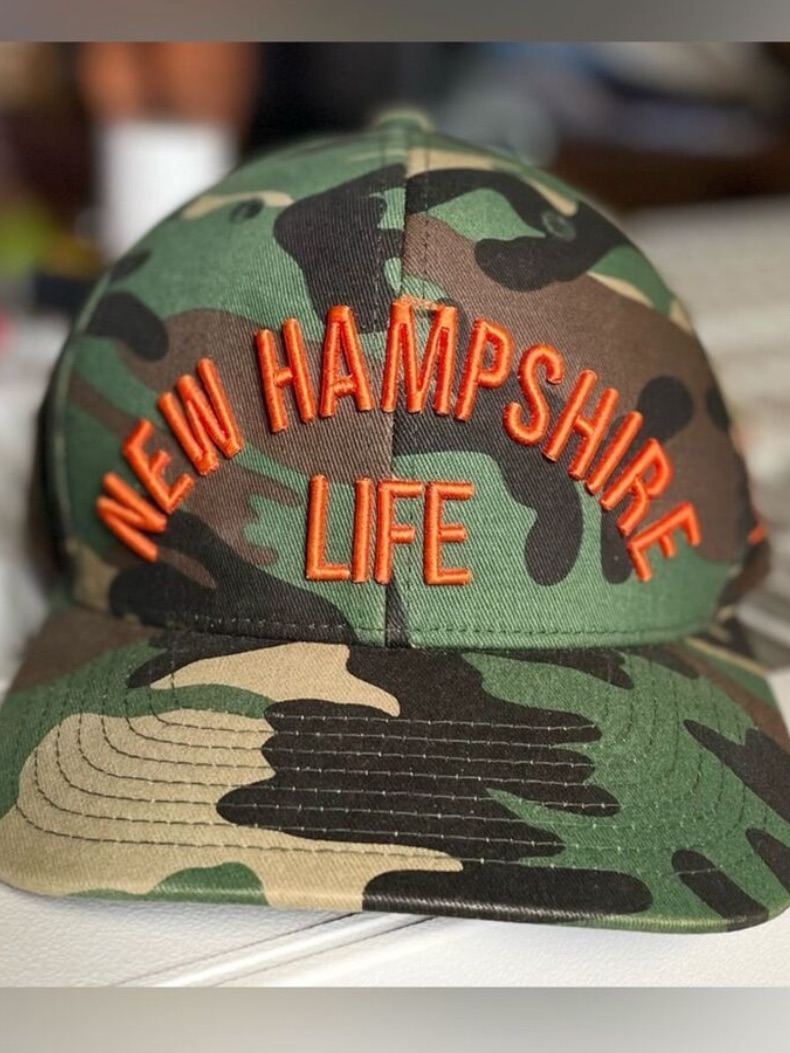New Hampshire Life Adjustable Camo Baseball Hat With Orange Embroidery & Logo